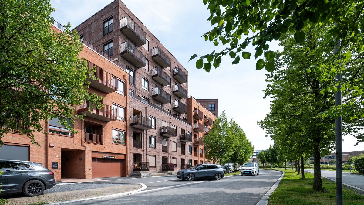 Modern residential development where a vehicle drives into a garage equipped with an integrated parking system.