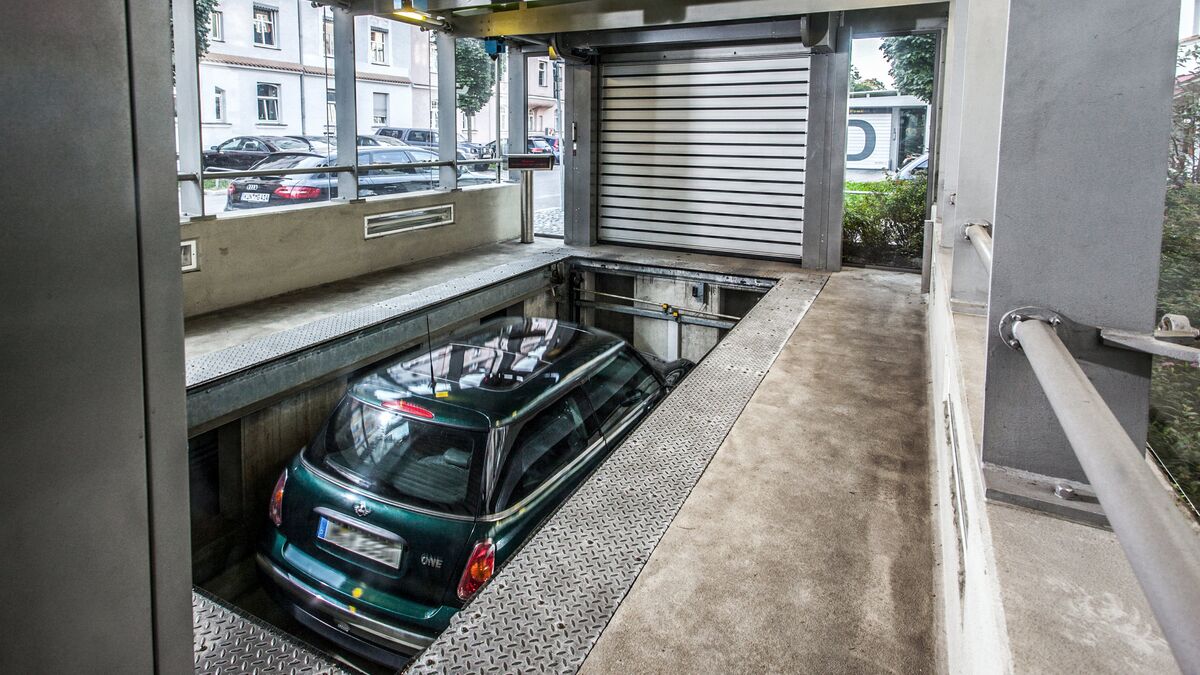The car is positioned on a parking platform in an entry bay and is lowered