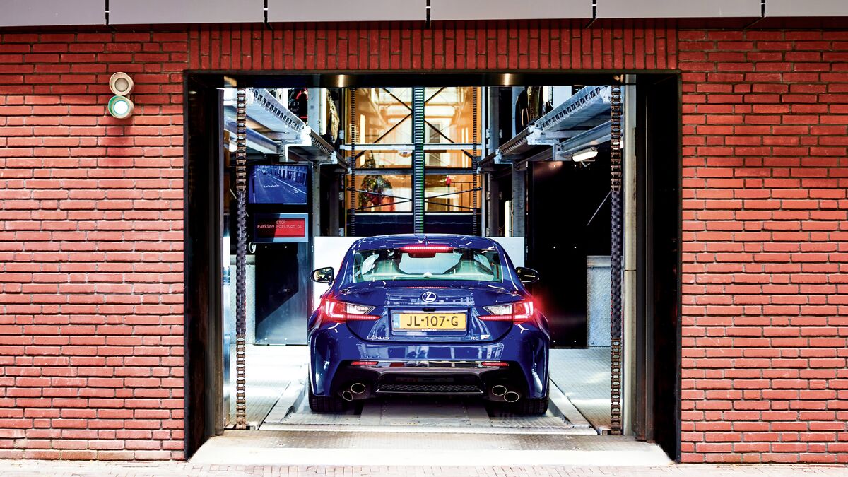 House wall with an open garage door into which a car is driving