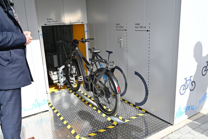 Bicycle on a guide rail in front of an automatic bicycle parking system