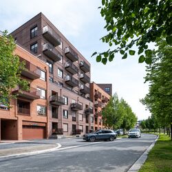 Modern residential development where a vehicle drives into a garage equipped with an integrated parking system.