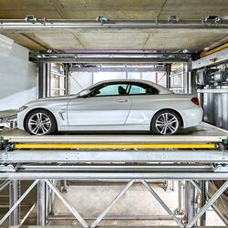 The car is parked on a parking platform in a multi-storey car park
