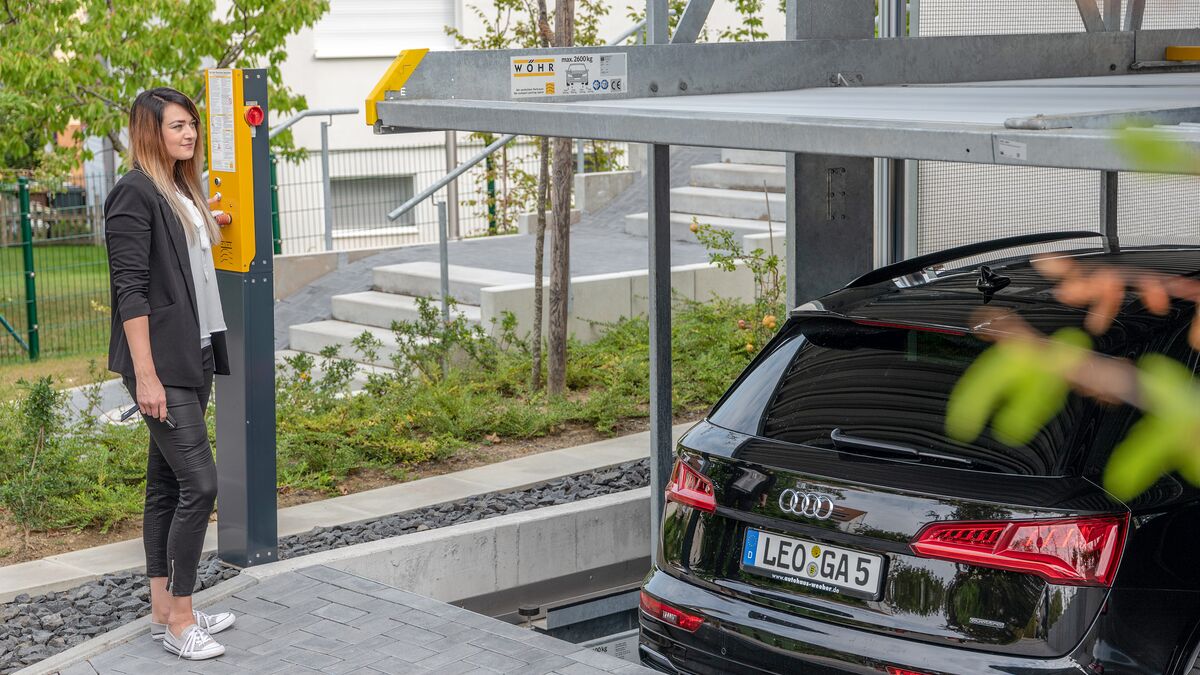 A woman operates a car parking system