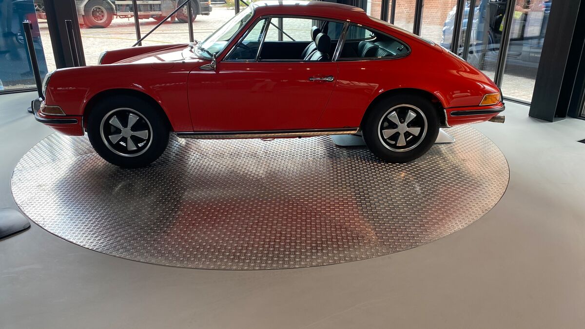 A red car is standing on a turntable