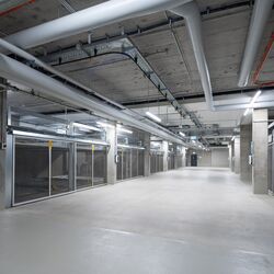 View of the aisle in the underground car park between the parking systems on either side