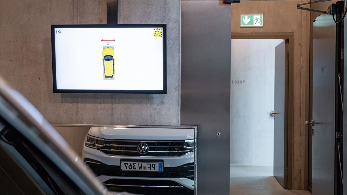 The car is positioned in front of a mirror and a monitor