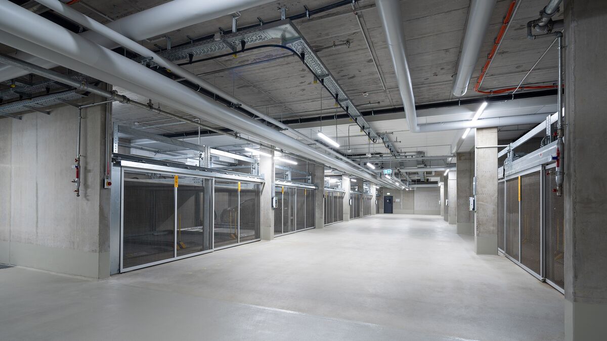 View of the aisle in the underground car park between the parking systems on either side